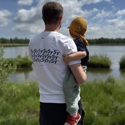 Fabian holding his son by a lake